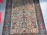 un tapis oriental posé à même le sol dans une pièce recouverte d'une moquette rouge