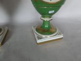 a green vase sitting on top of a white table