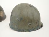 two helmets with holes in them are sitting on a white surface
