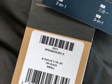 the label on the back of a black jacket with a barcode on it
