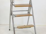 three step stools in a room with a white wall behind them
