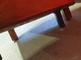 a cat that is sitting under a bed on the floor