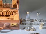 a suitcase with a lot of glass bottles and a mirror in it