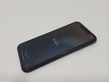 the back of a black cell phone sitting on top of a white table