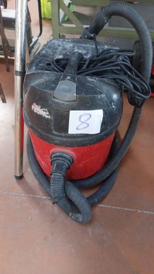un aspirateur posé sur le sol à côté d'une chaise