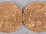 a close up of two gold coins on a white surface