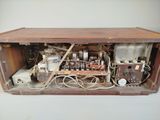 an old radio sitting in a wooden box on the wall