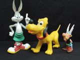 three figurines of bugs and a dog on a black background