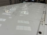 a white truck parked in a garage with a lot of windows