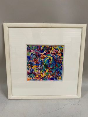 a white framed picture of a colorful abstract painting in a white frame