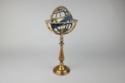 une image représentant un petit globe terrestre posé sur un socle, sur fond blanc