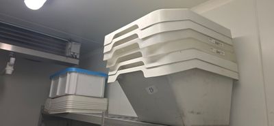 a stack of containers sitting on a shelf in a room