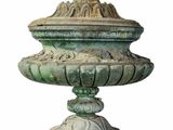 a large green urn on a pedestal with a bird on top