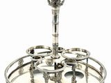 a silver plate with a candle holder on top of it
