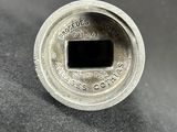 a close up of a silver coin on a black surface