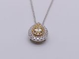 a yellow and white diamond pendant on a silver chain