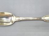 silver plated spoon with a curved handle on a gray surface