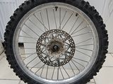 une roue de moto posée sur un sol carrelé