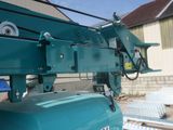 a green machine that is sitting on the side of a building