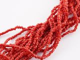 a close up of a bunch of red beads on a white surface