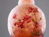 a glass vase with flowers painted on it on a stand