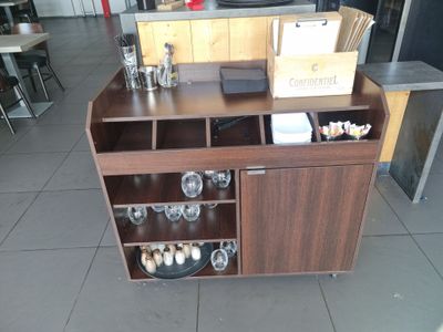 un comptoir en bois sur lequel sont posés un casier à bouteilles et des verres à vin