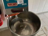 un grand saladier en métal contenant une cuillère en métal