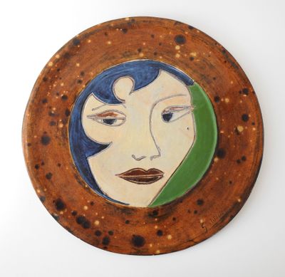 tableau représentant le visage d'une femme aux cheveux bleus, dans un cadre circulaire