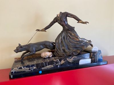 statue of a woman with a dog on a leash on a red table