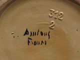 a brown vase with writing on it sitting on a table