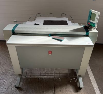 un ordinateur posé sur un bureau, à côté d'une imprimante