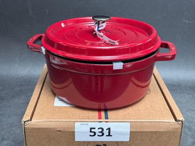 the large red pot is sitting on top of a cardboard box
