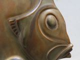 une statue représentant un poisson assis par terre