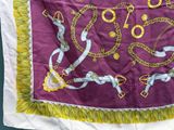 a close up of a purple and yellow scarf with chains on it