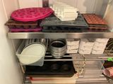 many trays and pans on the shelf in the kitchen