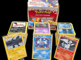 Plusieurs cartes Pokémon se trouvent dans une boîte sur fond noir.