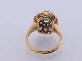 a close up of a gold ring with a green stone