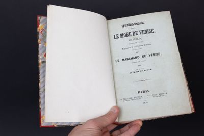 une personne tient un livre ouvert à la main sur un fond noir