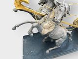 a statue of a horse pulling a carriage with a bird on it