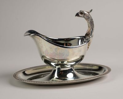 un plat ancien en argent orné d'un paon