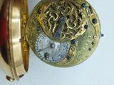 a person holding a gold pocket watch in their hand