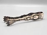 a silver spoon with a flower on it on a white surface