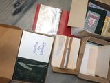 une boîte de livres et une paire de ciseaux posés par terre