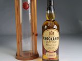 une photo d'une bouteille de whisky posée à côté d'un coffret en bois