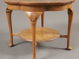 une table ancienne en bois, avec un plateau circulaire et deux pieds