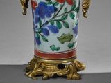 a vase with a handle that has flowers on it