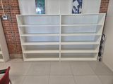 a white bookshelf with a red chair in front of it