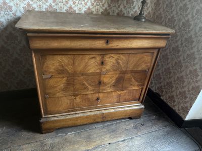 a small chest of drawers in the corner of a room