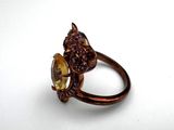 a gold ring with a face of a cat and a face of a flower