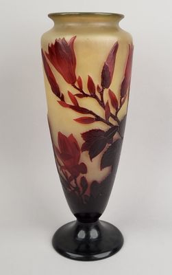 a vase with a red flower on it sitting on a table